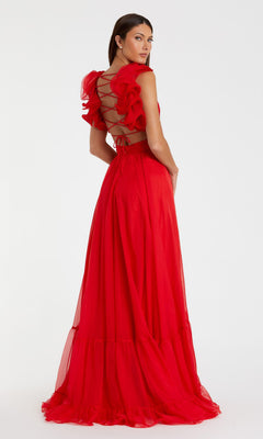 A woman models the Mac Duggal Empire-Waist Cut-Out Formal Dress 67911, a bright red lace-up prom gown with ruffles and an open back, posed against a plain white background.