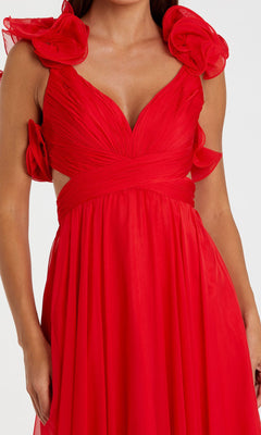 A woman wears the Mac Duggal Empire-Waist Cut-Out Formal Dress 67911 in red, featuring a sleeveless v-neck, ruched bodice, empire waist, and bold fabric flower shoulder accents.