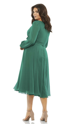 Woman with medium-length brown hair is wearing the Plus Long-Sleeve Short Green Party Dress 67914 and beige sandals, posing slightly turned.