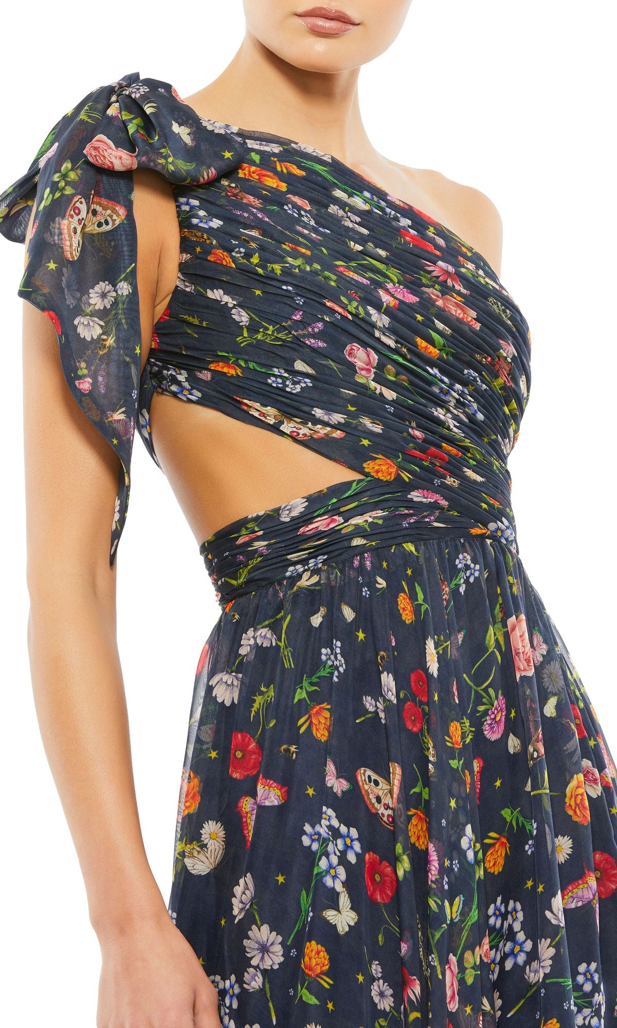 Woman wearing the Long Navy Print Prom Gown by Mac Duggal 67938—this one-shoulder dress features a side cutout, ruched detailing, and colorful flower and butterfly prints for a fresh twist on the classic floral prom dress.