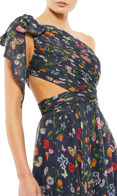 Woman wearing the Long Navy Print Prom Gown by Mac Duggal 67938—this one-shoulder dress features a side cutout, ruched detailing, and colorful flower and butterfly prints for a fresh twist on the classic floral prom dress.