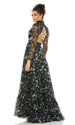 Woman in the Mac Duggal 67942 long black print formal dress with sheer long sleeves and lace-up open back, standing and looking over her shoulder.
