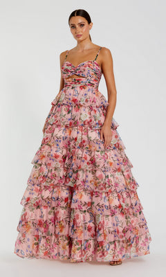 A woman models the Mac Duggal 67966 Violet Print Prom Ball Gown—a tiered, ruffled floral dress with thin straps—against a plain white background.