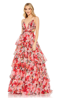 A woman stands facing forward in the Mac Duggal 67985 Pink Print Ruffled Formal Dress, featuring a sleeveless floral design with a deep V-neck, cutout sides, and a multi-tiered ruffled evening gown silhouette.