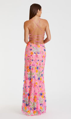 A woman stands with her back to the camera, wearing the Mac Duggal 68067 Sequin-Print Pink Formal Dress featuring crisscross straps and a long sequin floral skirt against a plain white background.