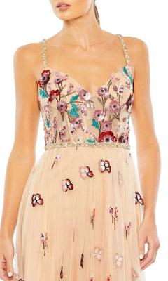 A woman wearing the Mac Duggal Embroidered Nude Formal Dress 681101 with colorful floral sequin embroidery and beaded straps.