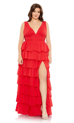 A woman models the Long Plus-Size Formal Dress 68119 by Mac Duggal—a sleeveless, floor-length gown with a ruched empire waist, layered ruffles, thigh-high slit—paired with white high-heeled sandals.
