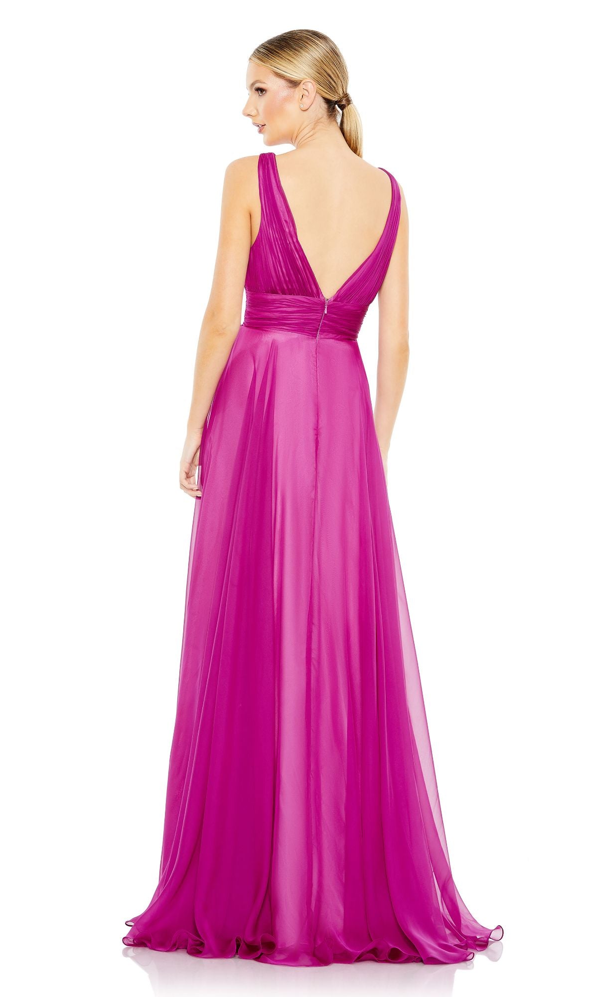 A woman faces away in the Mac Duggal 68134 fuchsia pink prom dress, featuring a deep V-back and an elegant A-line skirt that flows to the floor.