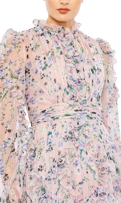 A woman wears the Long Formal Dress 68232 by Mac Duggal, a blush gown with long sleeves, blue and purple floral patterns, ruffles, and a high neckline.