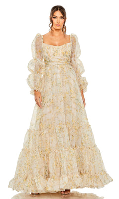 A woman models the Long Formal Dress 68288 by Mac Duggal—a flowing floral print gown with a ruched empire waist, puffed sleeves, and square neckline—standing against a white background.