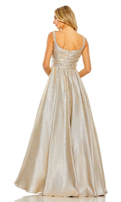 A woman stands facing away, wearing the Mac Duggal 68349 Long Glitter Prom Ball Gown—a sleeveless, floor-length A-line dress with a fitted bodice and flared skirt in striking metallic gold.