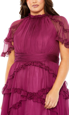 A woman wearing the Long Plus-Size Prom Dress 68424 by Mac Duggal, featuring magenta ruffle tiers, short sleeves, a high neckline, and layered waist and sleeve detailing.
