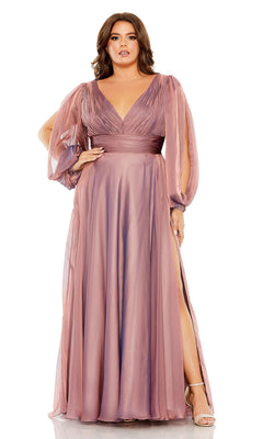 A woman stands confidently with one hand on her hip, wearing the Long Plus-Size Formal Dress 68431 by Mac Duggal—a mauve A-line gown with long sheer sleeves, deep V-neckline, ruched bodice, and thigh-high slit.