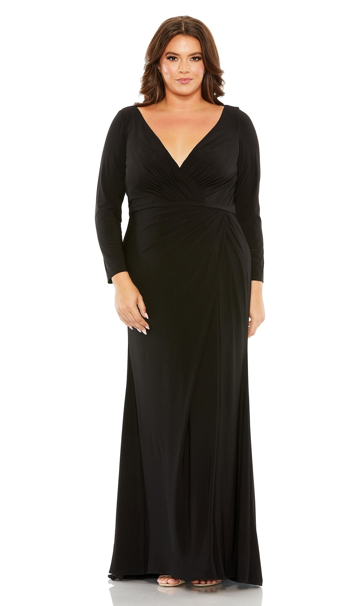 A woman wears the Long Plus-Size Formal Dress 68442 by Mac Duggal—a black, fitted, V-neck gown with a gathered waist—standing against a plain white background.