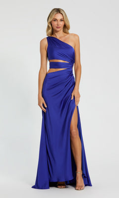A woman models the Mac Duggal 68485 One-Shoulder Cut-Out Formal Gown in royal blue, featuring a high slit and waist cut-outs, against a plain background.
