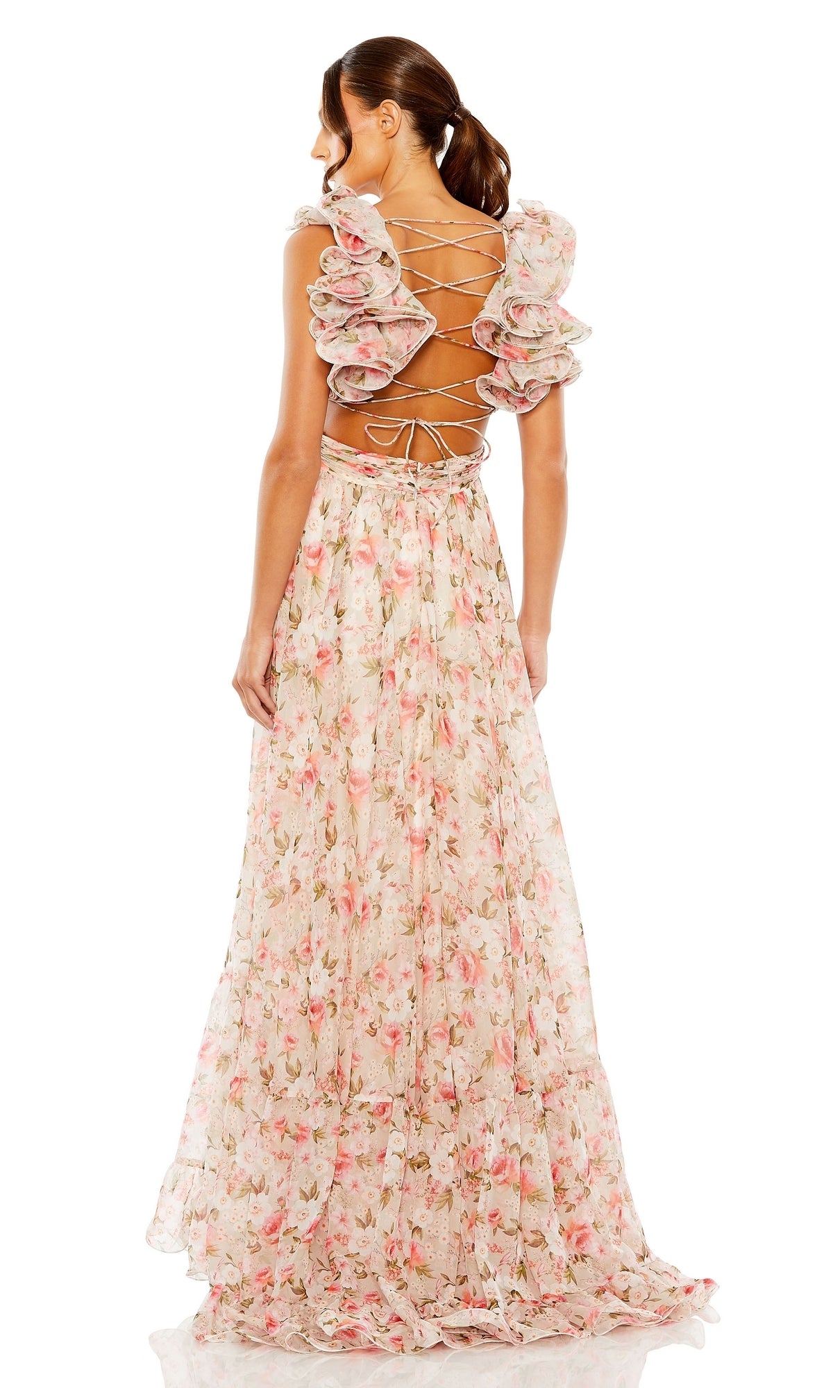 A woman poses with her back to the camera in the Mac Duggal Long Formal Dress 68519, a floor-length pastel floral gown featuring ruffles and an open back with crisscross lace-up detailing.
