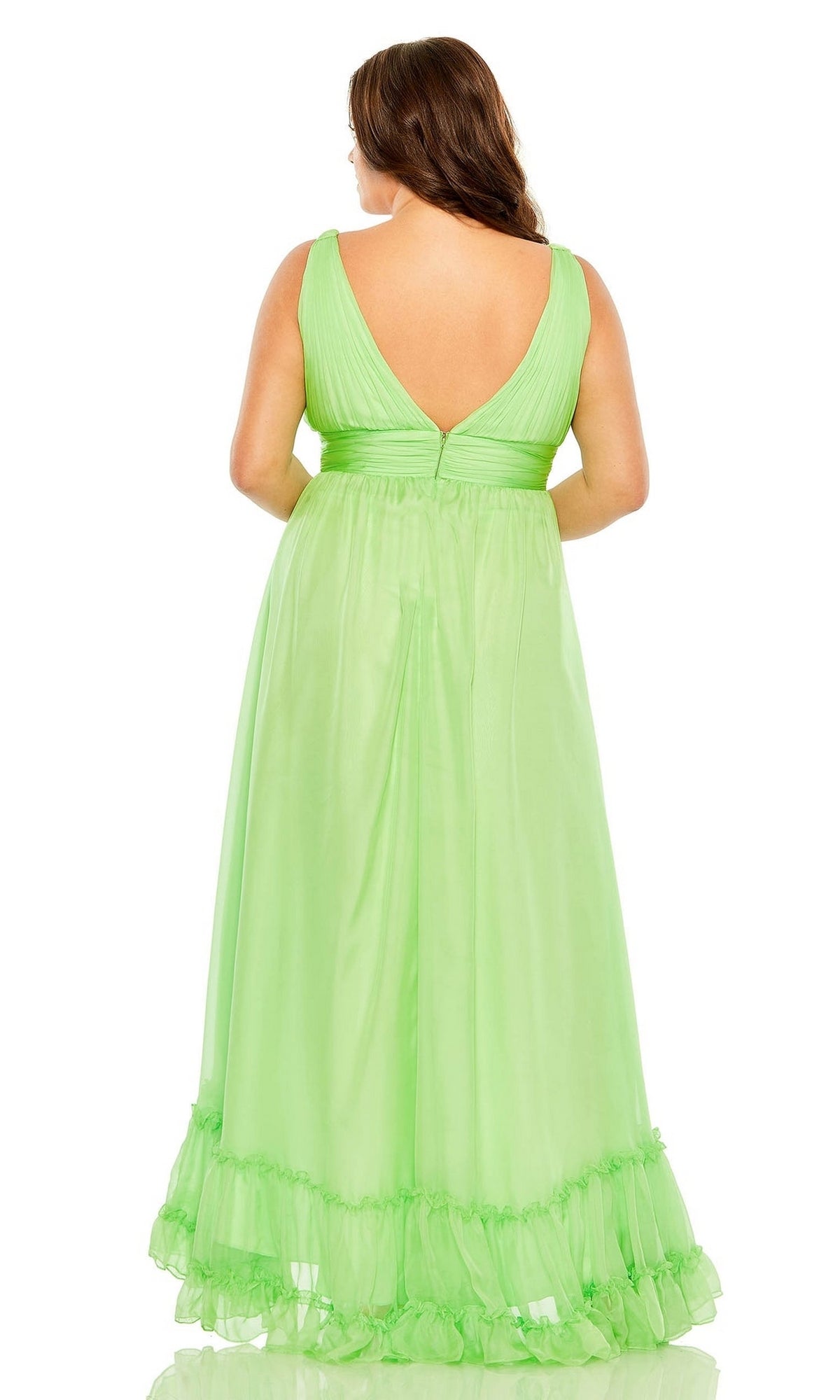 A woman stands with her back to the camera in the Long Plus-Size Formal Dress 68541 by Mac Duggal, a sleeveless, floor-length light green dress with a v-neck, deep V-back, and ruffle hem.