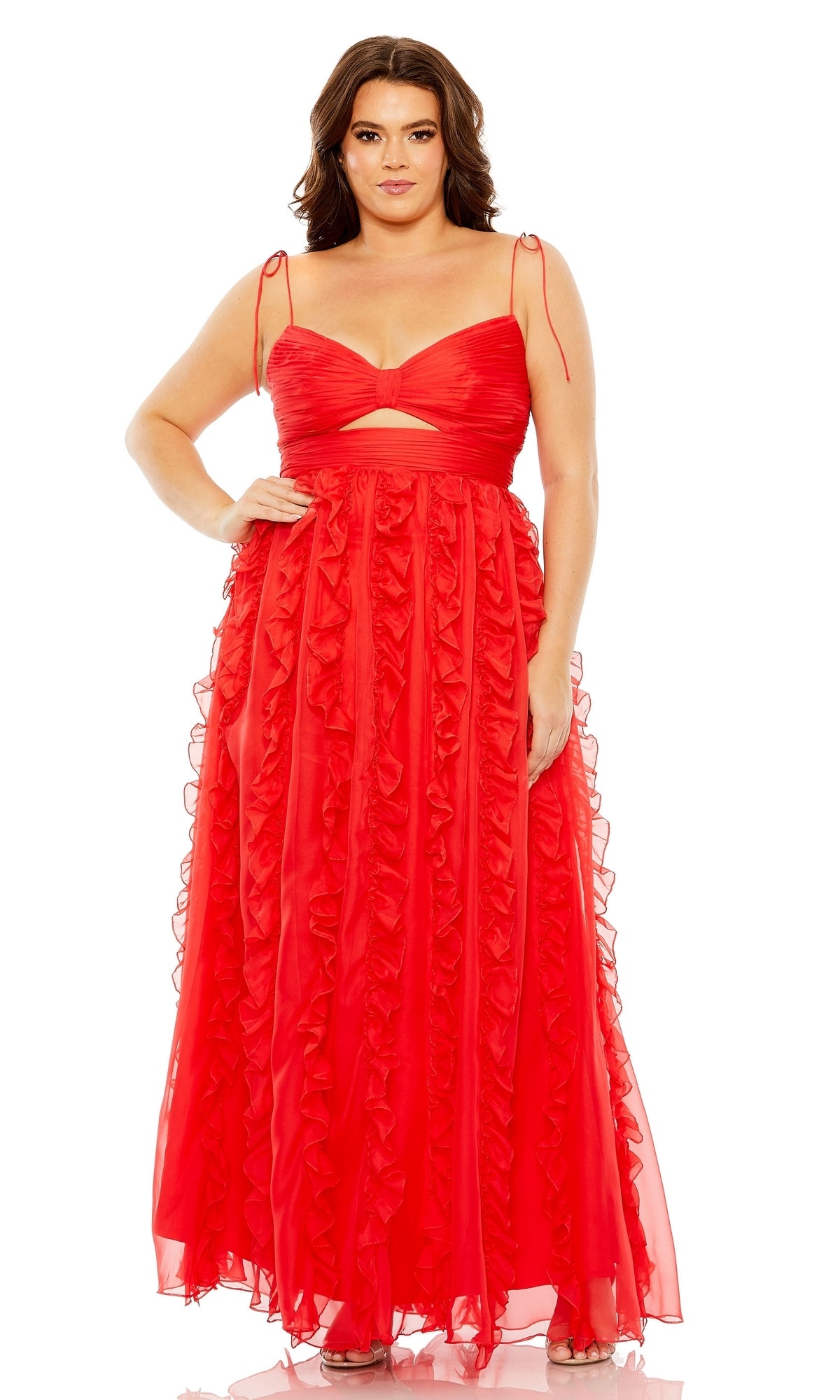 A woman stands facing forward in a sleeveless, floor-length Plus-Size Ruffle Formal Dress by Mac Duggal 68543, featuring ruffles and a cut-out under the bust.