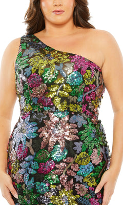 A woman wears the Long Plus-Size Formal Dress 68545 by Mac Duggal—a one-shoulder gown with black sequins and a vibrant floral pattern.