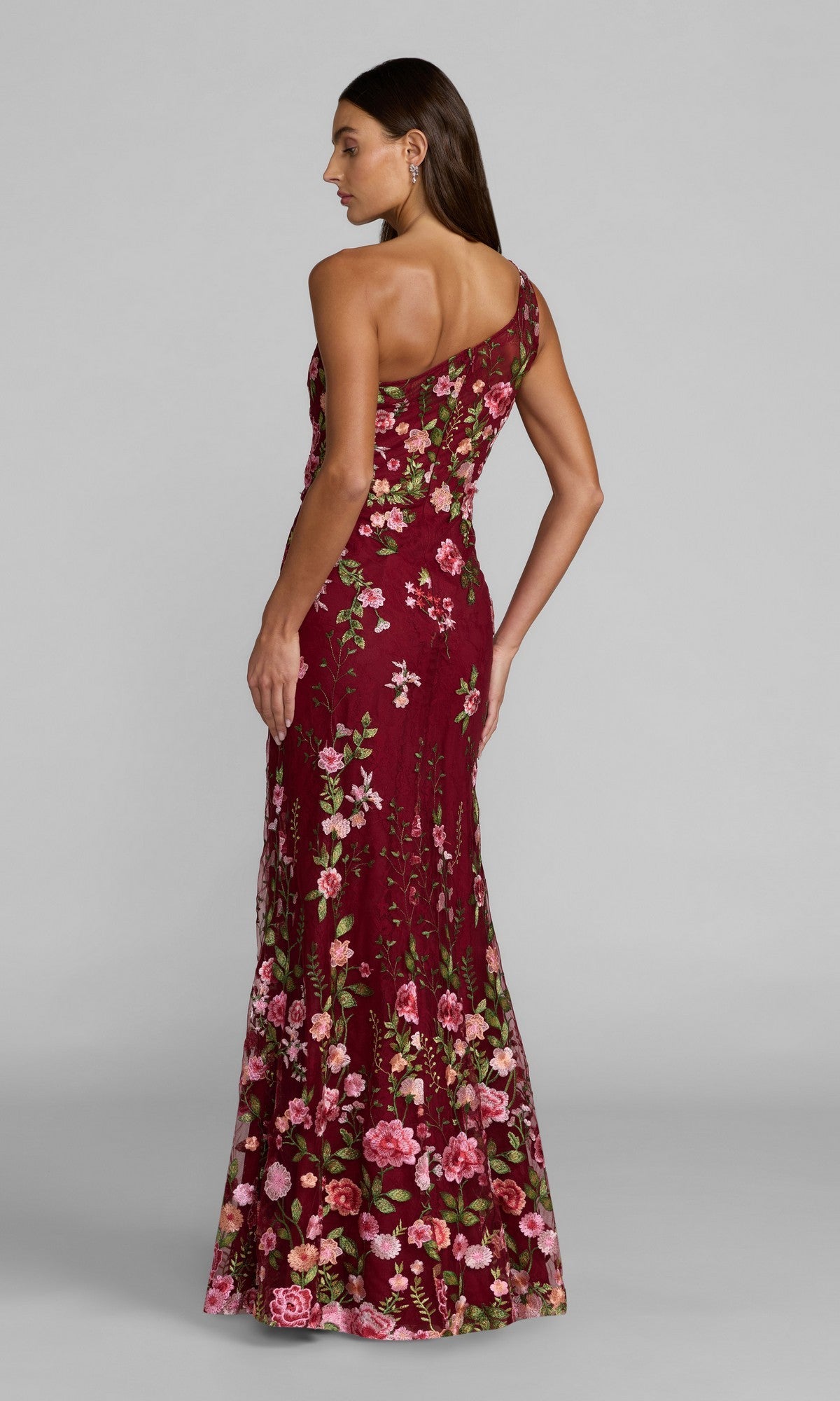 Model shows the back of the Mac Duggal 68606 Long Floral-Print Formal Dress—a floor-length, one-shoulder gown in burgundy with pink and green floral patterns.