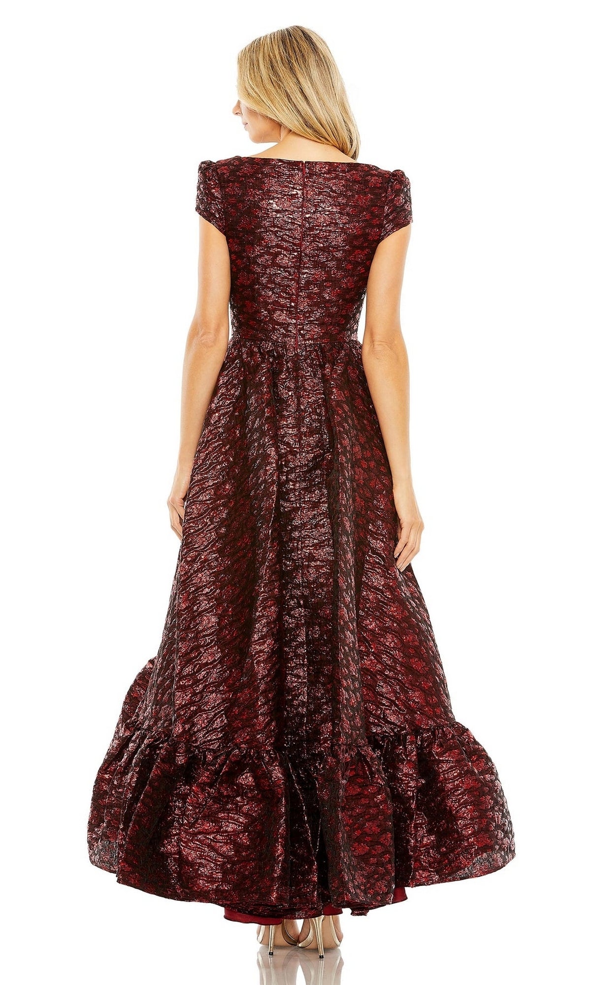 A woman faces away wearing the Mac Duggal Long Formal Dress 68623, a textured dark red brocade gown with short sleeves, a ruffled hem, and a visible back zipper.