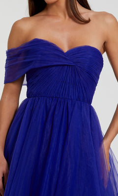 Woman wearing the Mac Duggal 68713: a one-strap long prom ball gown featuring pleated royal blue tulle, a fitted bodice, and a flowing skirt.