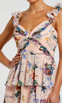 A woman wearing the Mac Duggal 68742 long formal dress, featuring sleeveless, light pink floral chiffon with ruffled straps, a ruched bustier bodice, and a layered peplum waist.