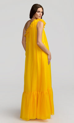 A woman poses against a plain light background, turning her head over her shoulder while wearing the Mac Duggal 68757 long formal dress in bright yellow with ruffled details.