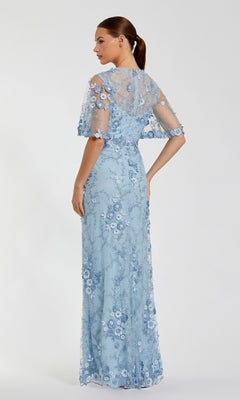 A woman models the Mac Duggal 68810 Flutter-Sleeve Long Formal Dress in light blue lace with floral appliqué and short sleeves, shown from the back against a plain background.