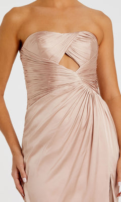 Wearing the Mac Duggal 68837, a strapless long formal dress in ruched light beige satin with a crisscross bodice and chest cutout—an elegant evening gown.