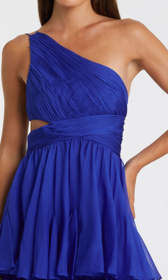 A woman models the Mac Duggal 68846, a one-shoulder blue formal dress featuring pleated detailing, a fitted bodice, and a flared skirt, posing confidently with one hand on her hip.