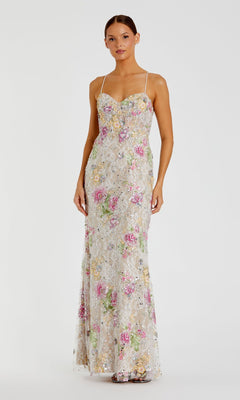 A woman is wearing the Mac Duggal 68891 long formal dress in Ivory Multi, a sleeveless, floor-length gown with thin straps, a fitted silhouette, and pastel floral sequin embroidery.