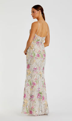 A woman stands facing away in the Mac Duggal 68891 long formal dress, featuring a sheer design with multicolored floral embroidery and thin straps, set against a plain white background.