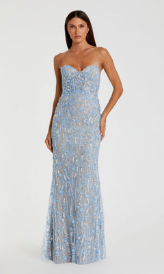 A woman wearing the Mac Duggal 68893 Long Formal Dress in blue, a strapless floor-length gown with a fitted silhouette, showcases intricate lace adorned with blue floral embroidery and delicate beadwork on a sheer overlay, set against a plain background.