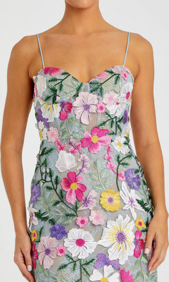 A woman wears the Mac Duggal 68897 long formal dress, a sleeveless evening gown with thin straps and colorful floral embroidery on sheer fabric.