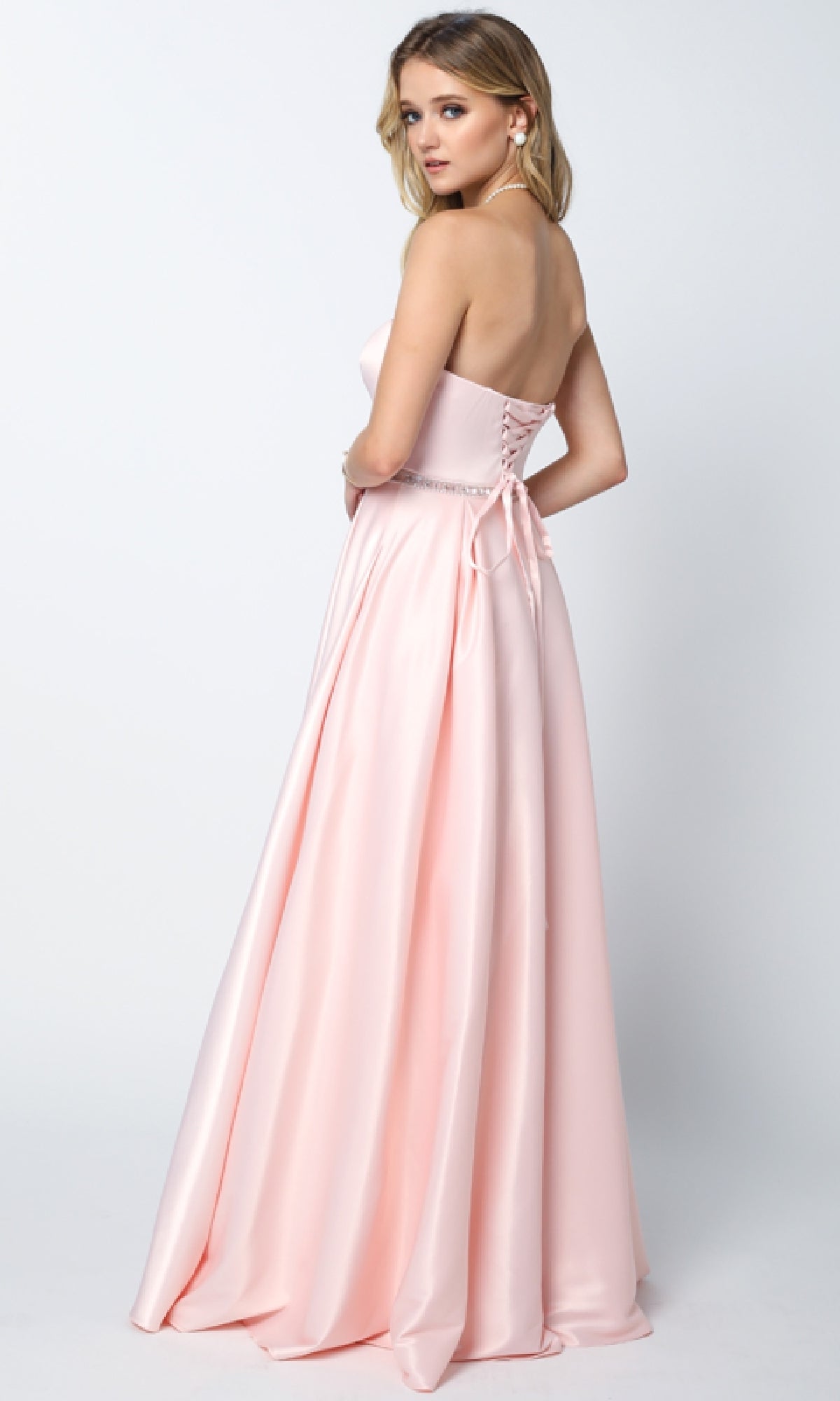A woman in the Long Prom Dress: Juliet 688 showcases its timeless charm with a pink strapless design, sweetheart neckline, and elegant a-line silhouette.