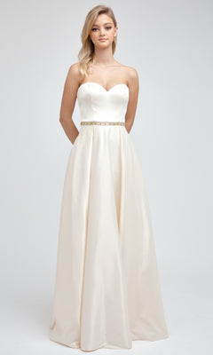 A woman poses against a plain background wearing the Juliet 688 Long Prom Dress—an ivory, floor-length strapless gown featuring a sweetheart neckline and a slim embellished waist belt.