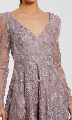 A woman wearing the Mac Duggal 68908 long formal dress in mauve, featuring sheer long sleeves, intricate floral embroidery, and a deep V-neckline.
