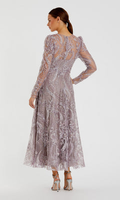 A woman, seen from behind, stands against a plain white background wearing the Mac Duggal 68910 tea-length party dress—a mauve design with long sleeves and floral embroidery—paired with silver heeled sandals.