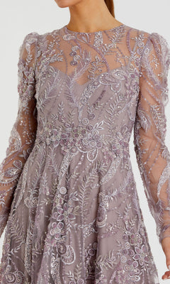 A woman wearing the Mac Duggal 68910 Tea-Length Party Dress—a lilac long-sleeve gown featuring intricate, sheer floral embroidery and a fitted waist—shown from shoulders to knees.