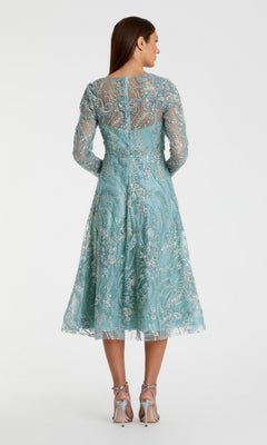 A woman stands in heels, seen from the back against a plain white background, wearing the Mac Duggal 68915 Midi Party Dress—a light blue, long-sleeved dress featuring floral embroidery and a graceful fit-and-flare midi silhouette.