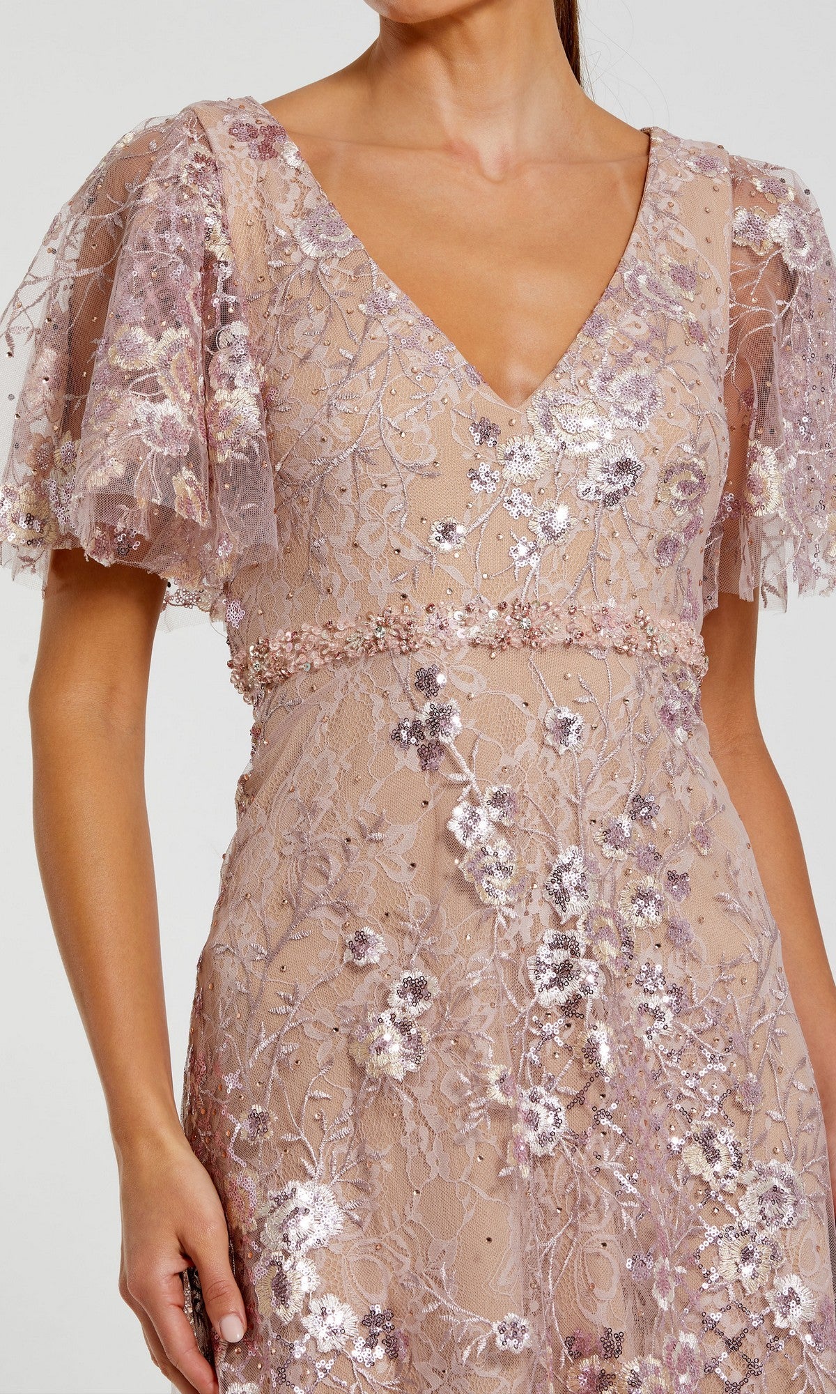 Woman wearing the Mac Duggal 68922 Long Formal Dress in light pink, featuring sequin floral embroidery, short flutter sleeves, and a deep V-neckline. Only the upper body is visible.