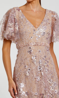 Woman wearing the Mac Duggal 68922 Long Formal Dress in light pink, featuring sequin floral embroidery, short flutter sleeves, and a deep V-neckline. Only the upper body is visible.