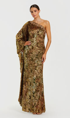 A woman stands against a plain white background wearing the Mac Duggal 68981 One-Shoulder Gold Formal Gown, a floor-length evening dress with metallic gold and green hues and a draped one-shoulder sleeve.