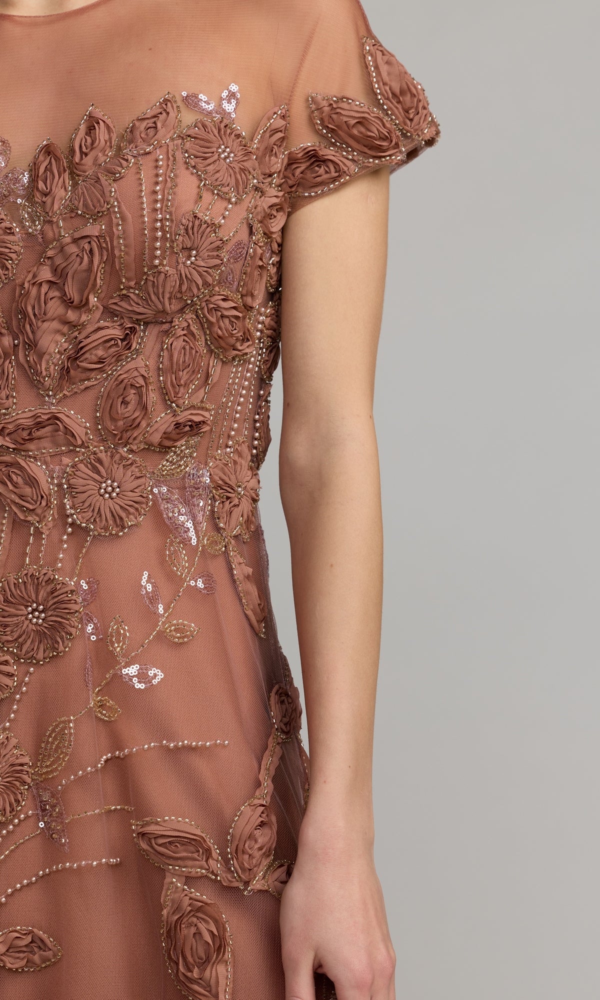 A person wearing the Cap-Sleeve Black Formal Dress: Mac Duggal 69003, featuring sheer short sleeves with 3D floral appliqué and intricate bead embellishments, is shown from shoulders to mid-thigh against a plain background.