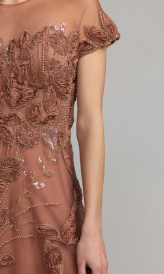 A person wearing the Cap-Sleeve Black Formal Dress: Mac Duggal 69003, featuring sheer short sleeves with 3D floral appliqué and intricate bead embellishments, is shown from shoulders to mid-thigh against a plain background.