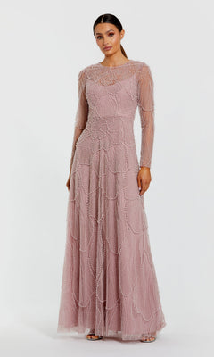 A woman wearing the Mac Duggal 69012 long formal dress in mocha, featuring sheer long sleeves and intricate pearl beaded patterns, stands against a plain white background.
