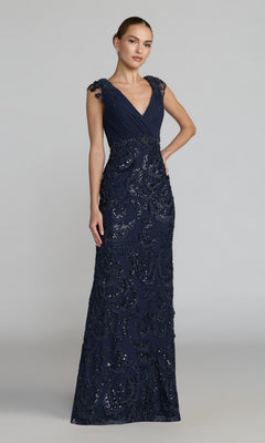 Woman wearing the Long Beaded Rose Formal Dress: Mac Duggal 69022, a floor-length, sleeveless navy gown with a deep V-neckline and sequin embellishments, stands against a plain light gray background.