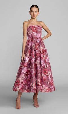 A woman stands with one hand on her hip, wearing strappy high-heeled sandals and the Mac Duggal 69109 Tea-Length Party Dress in Pink Multi—a strapless cocktail dress featuring a full skirt and exquisite floral sequin embroidery.