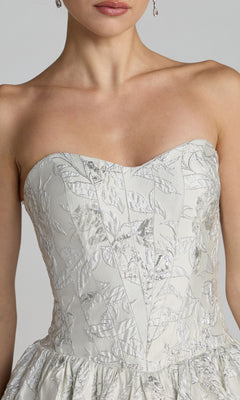 Close-up of a woman wearing the Tea-Length Party Dress: Mac Duggal 69146, featuring a strapless sweetheart bodice in white with silver leaf patterns and textured fabric, shown from chest to upper waist.